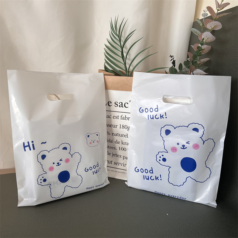 子供服の店の手提げ袋のプラスチックを持って、透明な四本の指を厚くします。