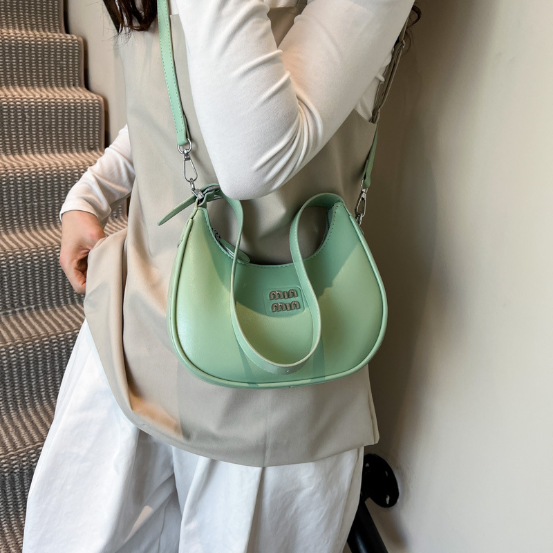 Bolso de axila de fuego súper transfronterizo para mujer 2025 nueva versión coreana de la bolsa de media luna de diseño de nicho bolsa de bola de masa cruzada de sentido avanzado