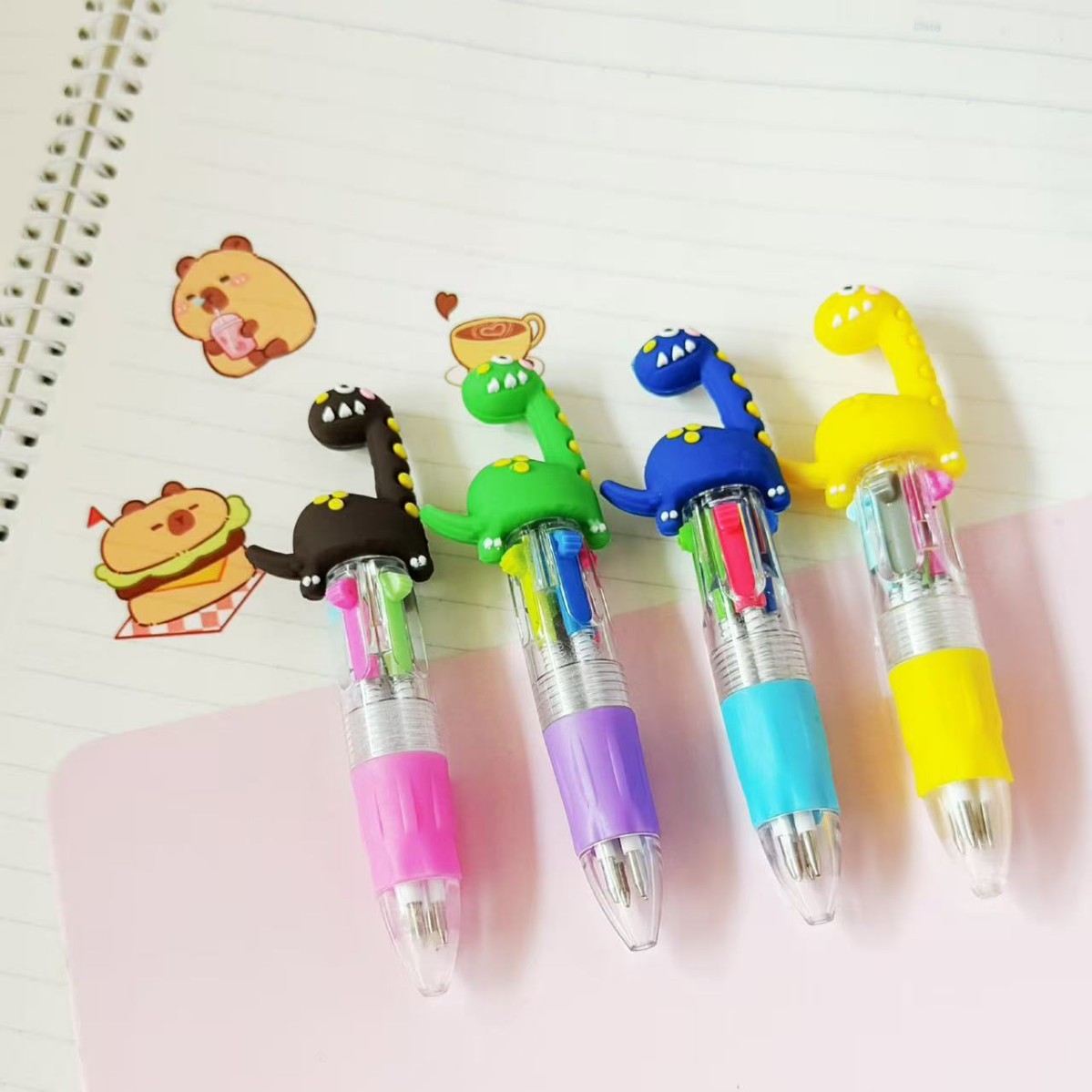 Bolígrafo pequeño de cuatro colores con diseño de dinosaurio moteado.