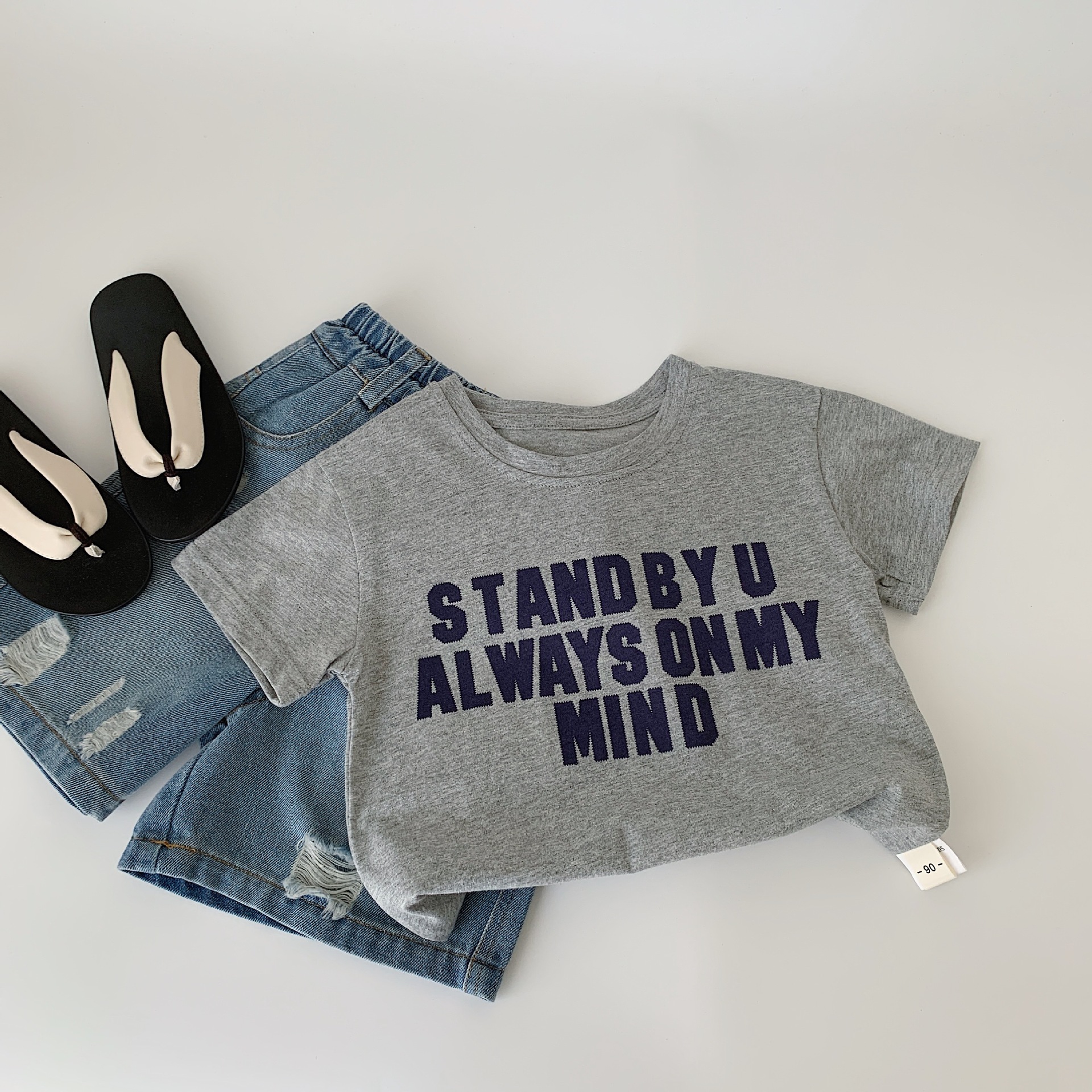 Camiseta de manga corta de verano para niños Maibao 2025 nuevo suéter de letras de dibujos animados para niños y niñas Huzhou Zhili ropa para niños a