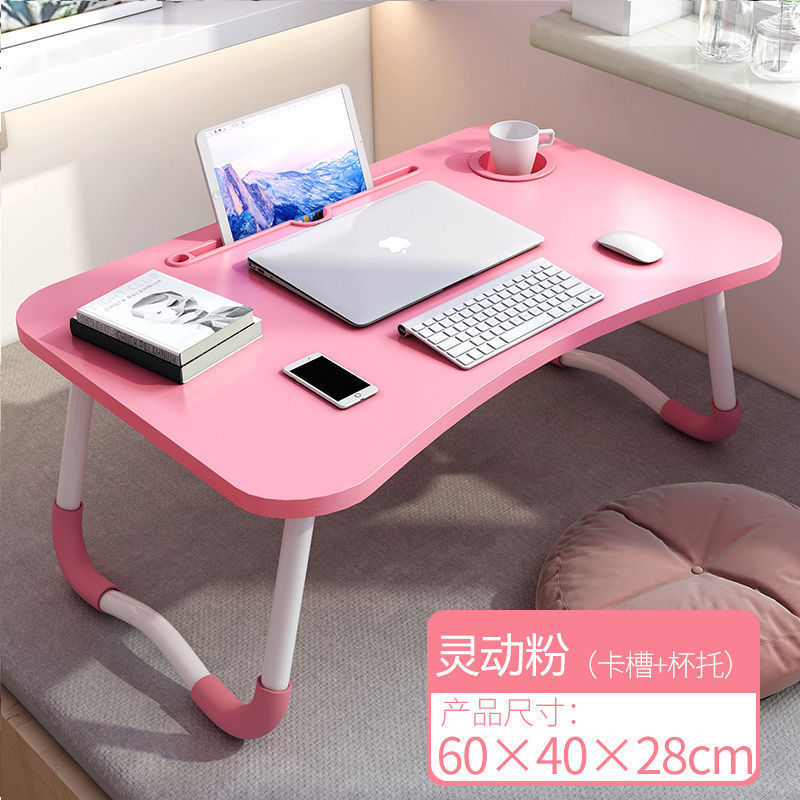 ベッドの上の机の折り畳みの小さい机は引き出しを持っています。|undefined