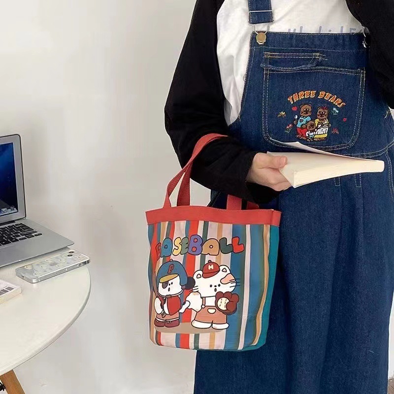 かわいい落書きバケツバッグinsプリント円筒バッグキャンバス弁当袋韓風少女は弁当箱を持っています。|undefined