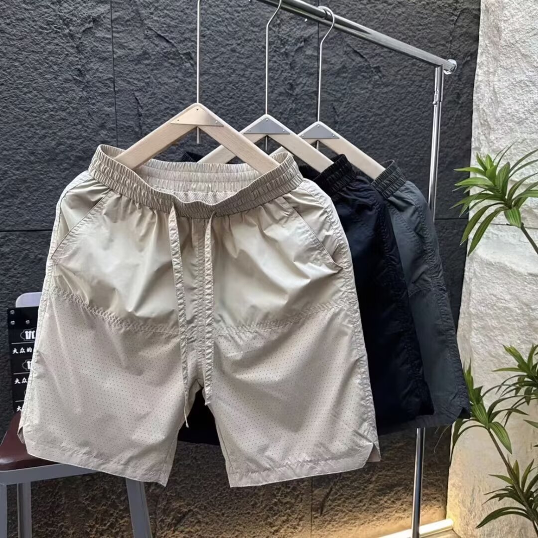 Verano nuevo estilo láser perforado transpirable pantalones cortos casuales hombres simples y de moda todo fósforo sueltos de seda de hielo de secado rápido pantalones de cinco puntos