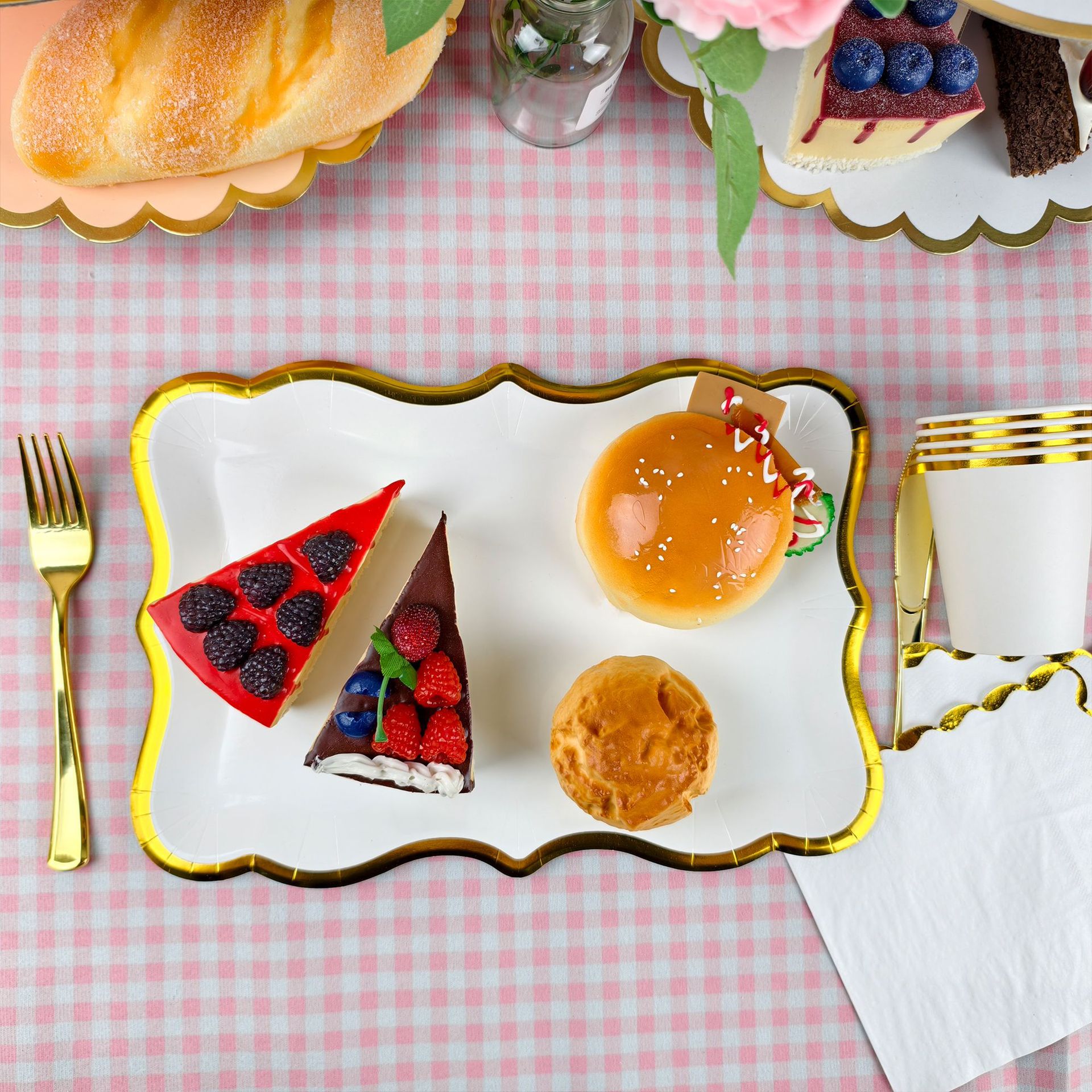 Elegante set di stoviglie monouso bianche con finiture dorate per feste: piatti rettangolari, tovaglioli e bicchieri per riunioni eleganti._voghion.com