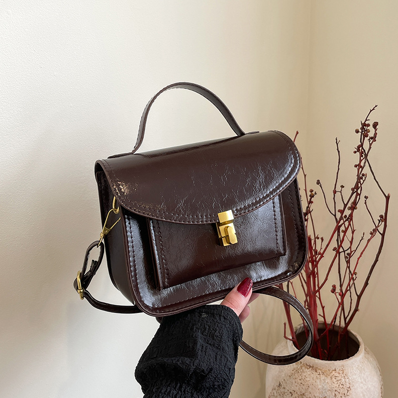 Bagos portátiles de estilo extranjero 2025, primavera nueva moda de nicho, bolsos de hombro de moda, bolsos de bloqueo personalizados, bolsos de mujer de tramo inclinado