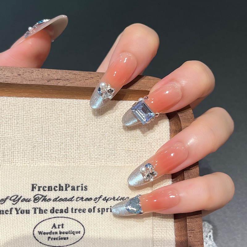 Uñas postizas francesas con diseño floral dorado, estilo ojo de gato, cortas y desmontables, producto de alta gama para arte de uñas 2026.