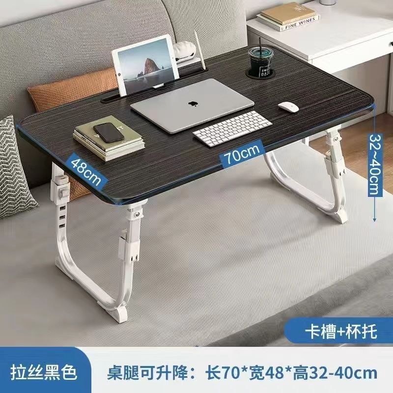 ベッドの上の小さい机のノートパソコンの机の上で折り畳みます。|undefined