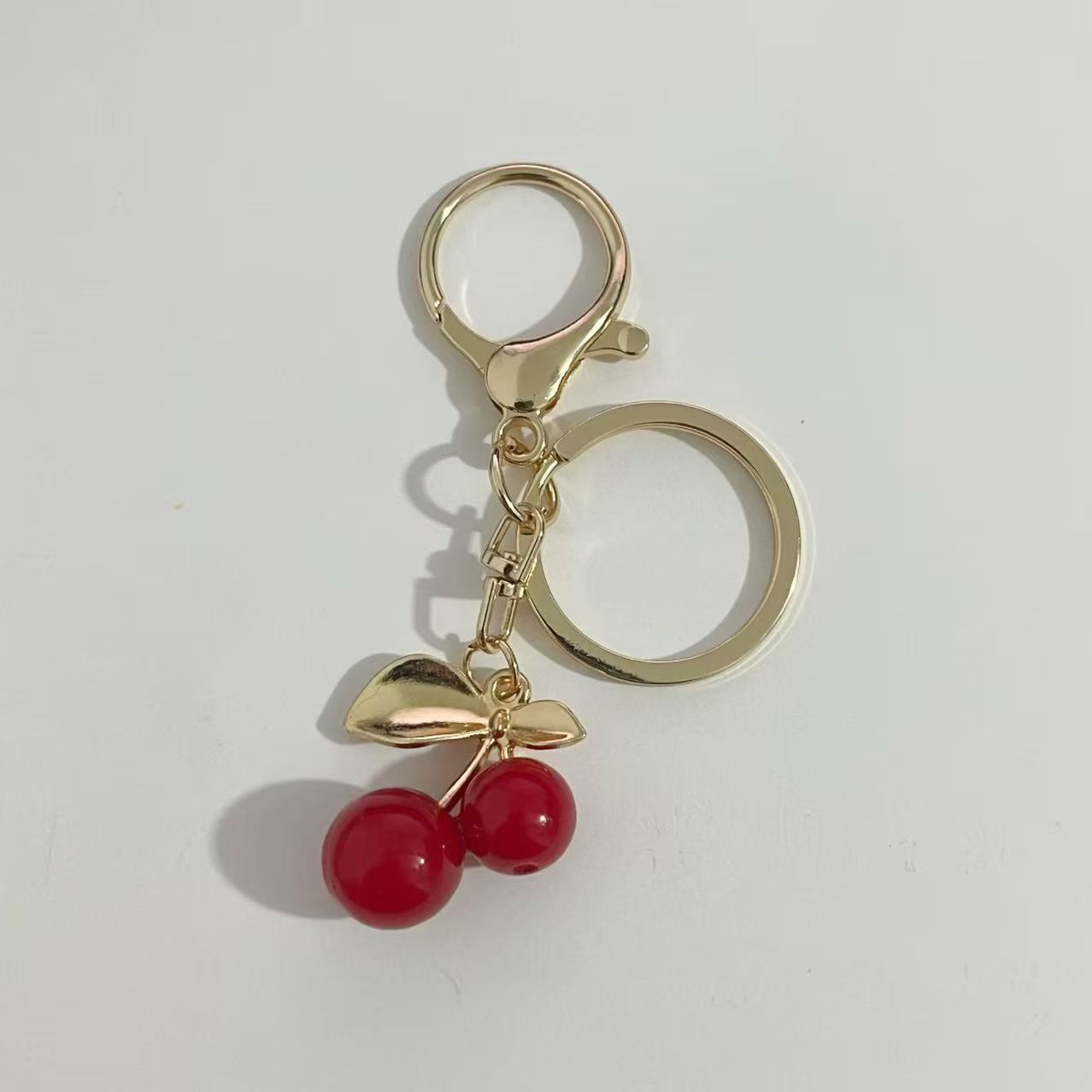 Nuevo estilo transfronterizo de moda europea y estadounidense delicado llavero de cereza de alta calidad sensación de bolsas de automóviles colgante colgante al por mayor
