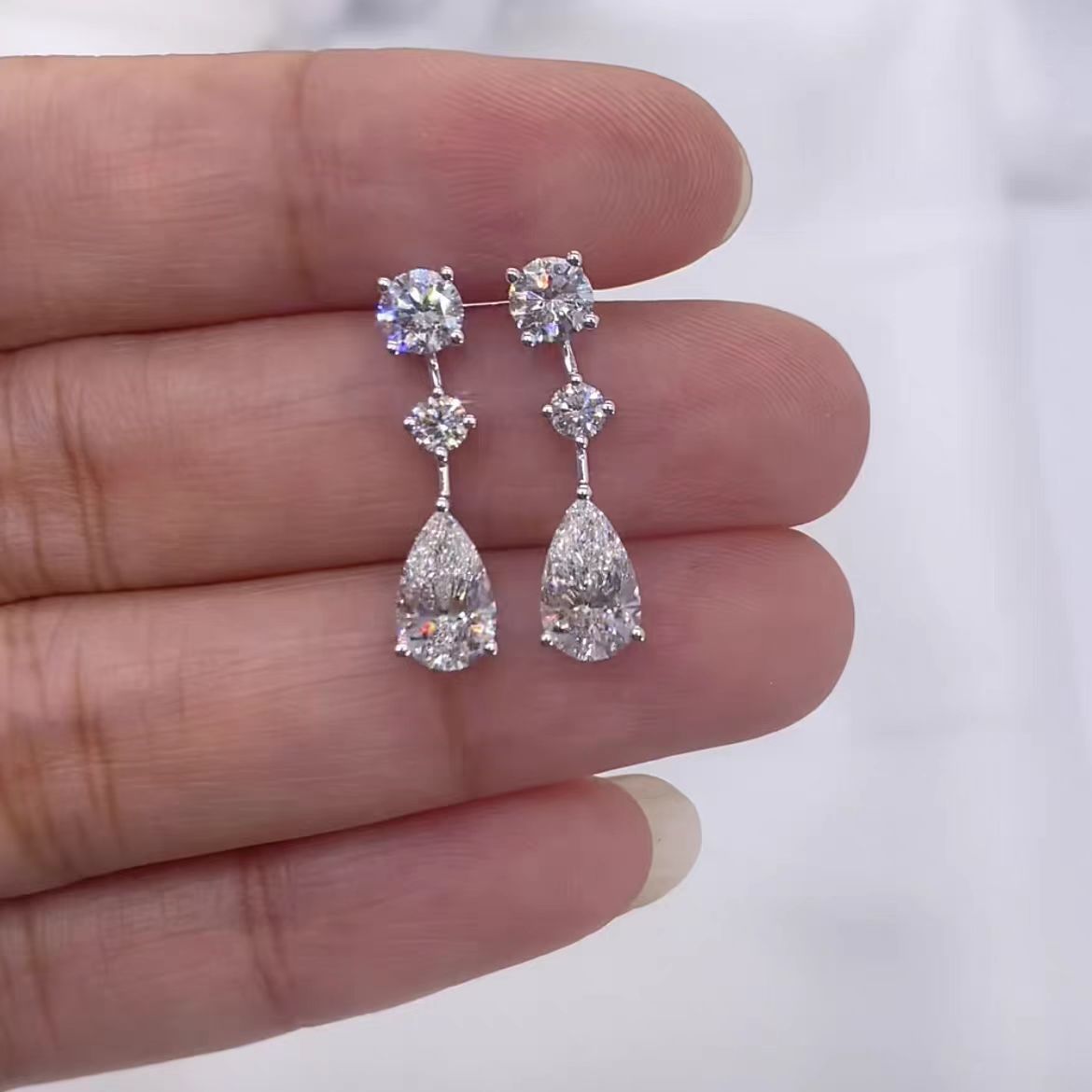 Teardrop earrings with a unique design, featuring a moon goddess's tear pendant adorned with sparkling diamonds, a minimalist and niche design, exuding a sense of understated luxury and sophistication.