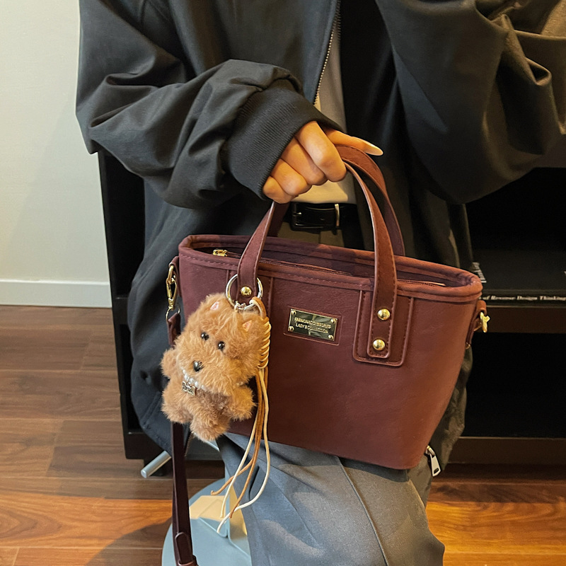 Alta sensación retro esmerilado bolso de cubo portátil 2025 otoño y invierno nuevo bolso de hombro de mujer de viaje versátil mochila