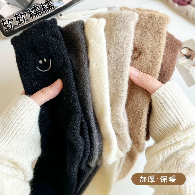 秋冬のベルベットは保温ストッキングを厚くして、オーストラリアのベルベットは毛を落とさない月子靴下刺繍笑顔の中筒に靴下を積んでいる女性|undefined