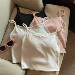 ギャルレースのレースストラップベストの女性は蝶結びの胸のクッションを持っています。