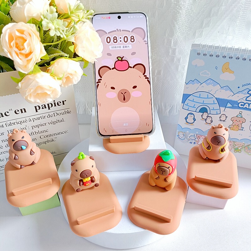 創意カピバラの子供の携帯電話のスタンドは携帯電話を並べてタブレットのデスクトップの棚に座って携帯します。|undefined
