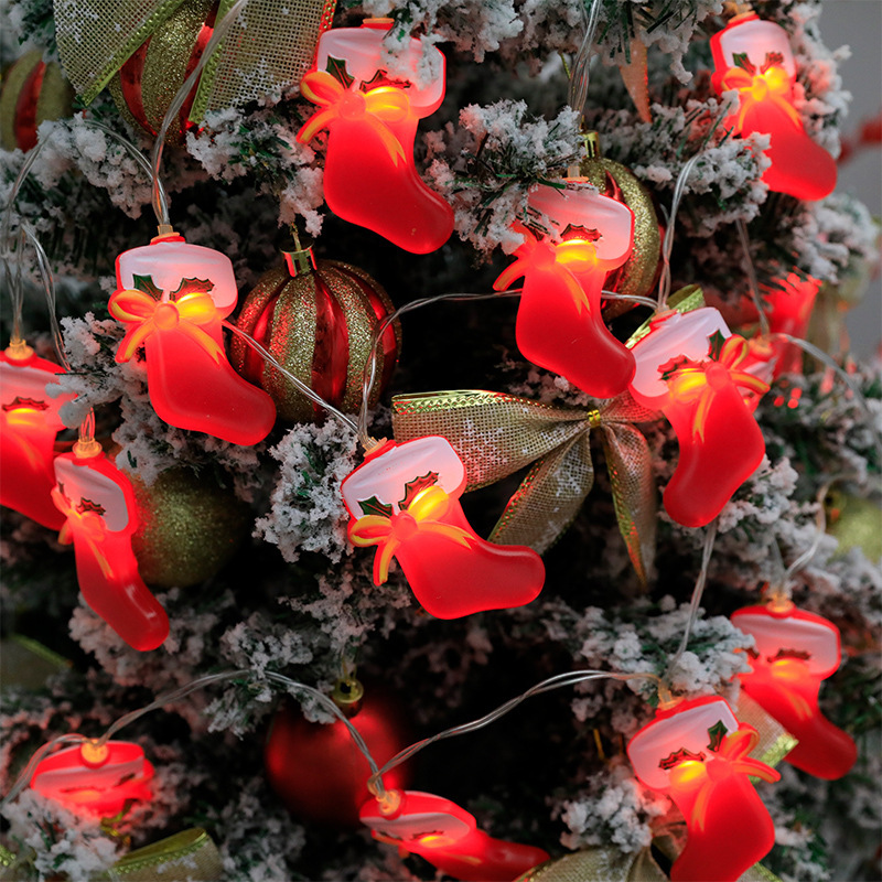 Sombreros rojos de Navidad, calcetines de Navidad, campanas de Navidad, cadenas de lámparas de navidad, pequeñas luces de color