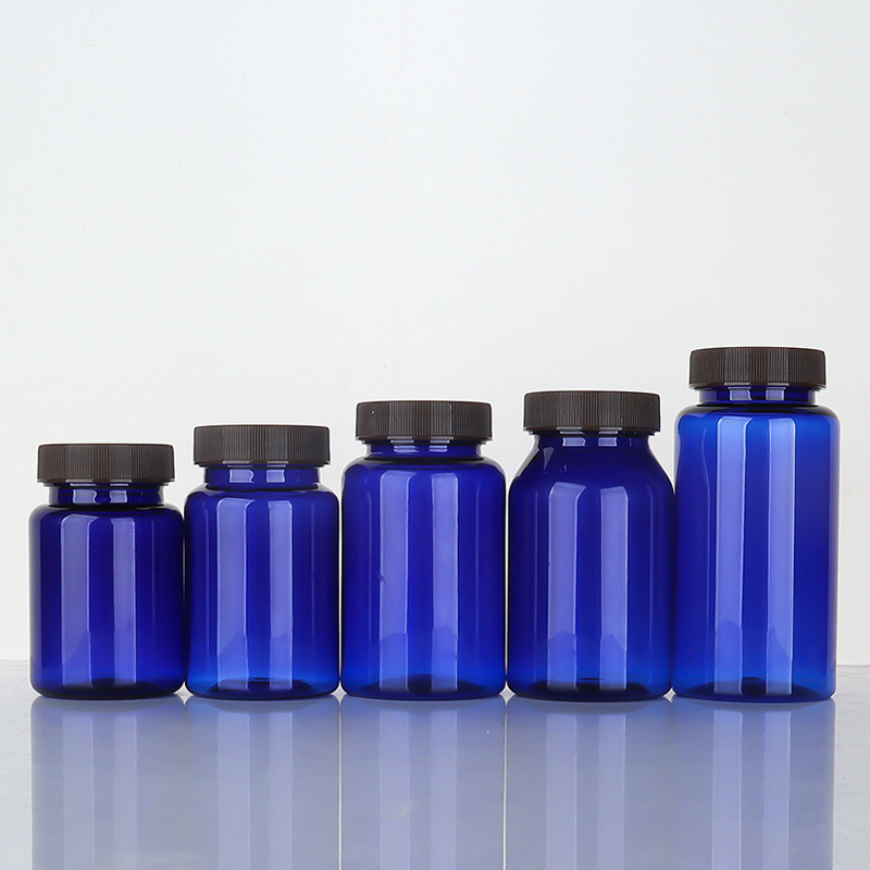Botella de plástico azul 80–150 ml con tapa estriada, envase para suplementos o cápsulas.