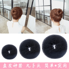 女の子のヘアアイロンの団子の頭のつぼみの髪はふわふわしています。