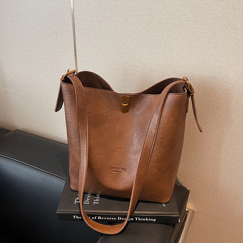 Bolsa de viaje retro coreana para mujeres 2025 invierno nuevo paquete de cubo de hombro de gran capacidad bolsa de mochila casual