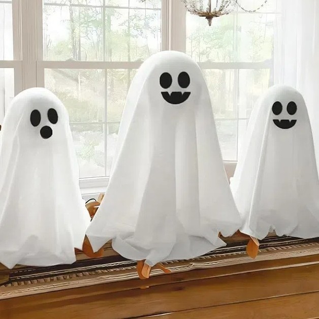 国境を越えたハロウィーンの幽霊テーブルがかわいいテーブルを並べて人形を飾るプラスチックの雰囲気テーブルが店のバーに飾られている|undefined