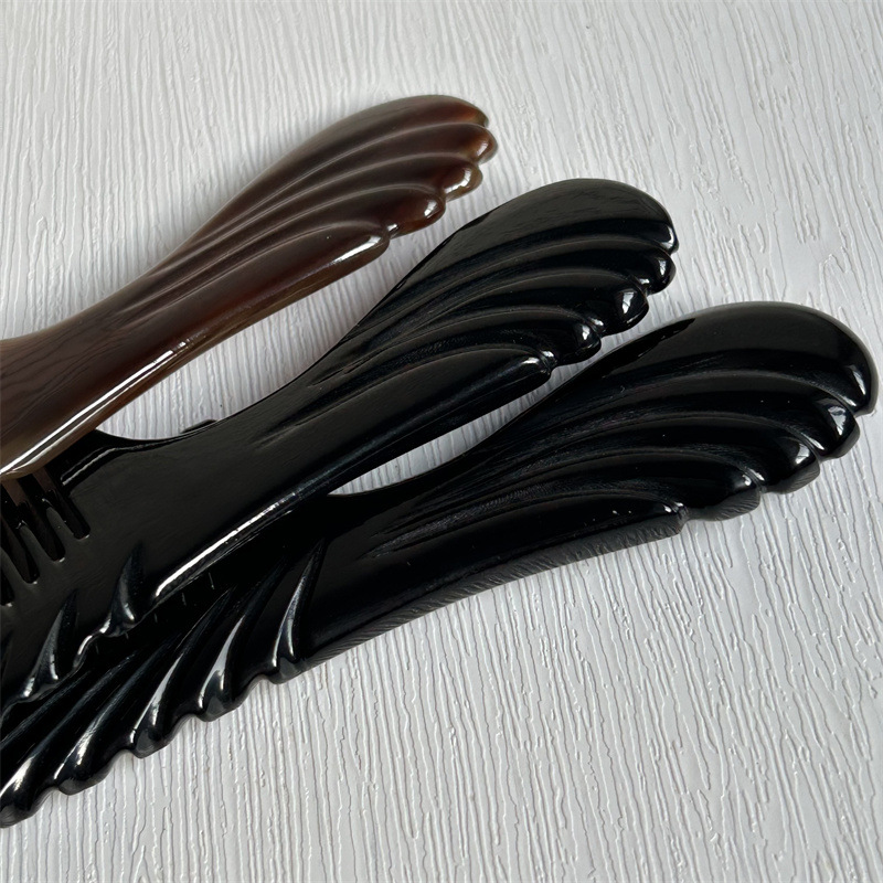 16cm Carved Ox Horn Comb Long Handle Gua Sha Hair Comb Black Flower Pattern in use