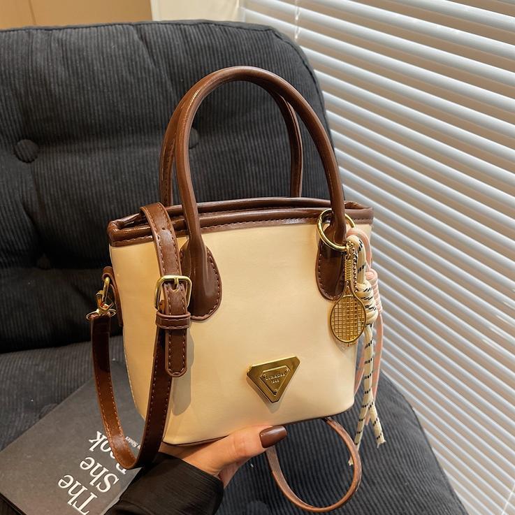 Bolso de mano de moda versátil para mujeres 2025 nuevo color de contraste de moda de un solo hombro bolso de cubo de alta sensación de mochila casual
