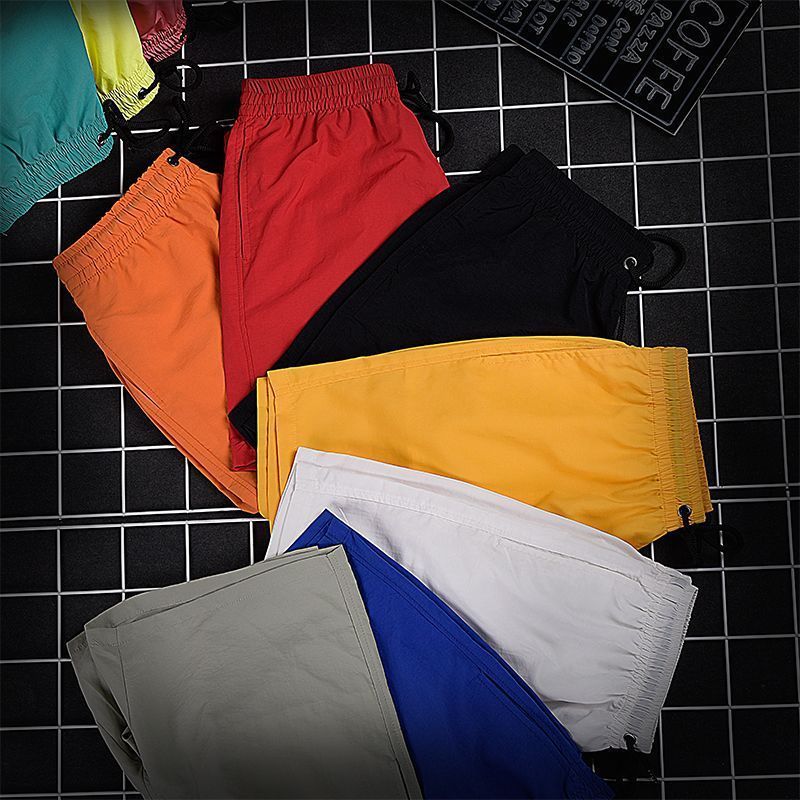 Pantalones de cuatro puntos Pantalones cortos casuales de verano para hombres Pantalones de playa de color caramelo para hombres de moda Pantalones de tres puntos deportivos sueltos de secado rápido
