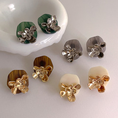 個性的な金属の花はアクリルのイヤリングをつなぎます。