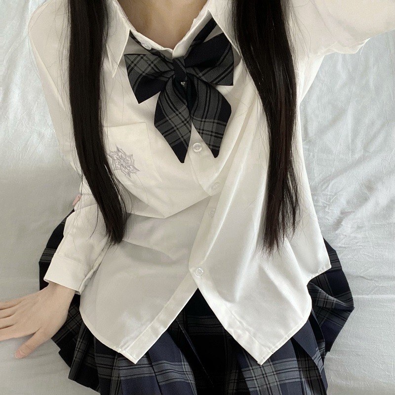 Белая рубашка с длинными рукавами и вышивкой.