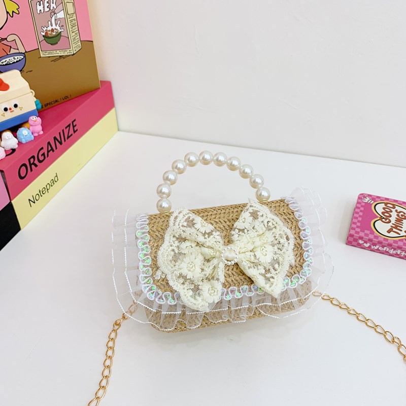 2025 verano nuevo arco de paja bolsa de perla portátil inclinada pequeña fragancia bolsa de moda para niños mochila para niñas