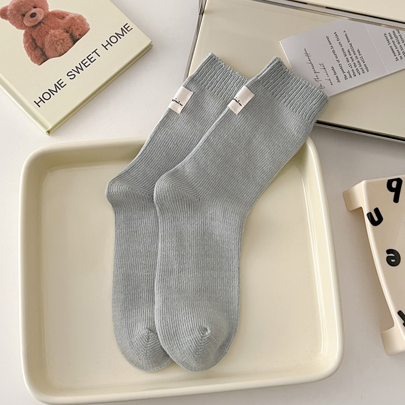 Otoño e invierno Nuevos calcetines de algodón absorbentes de sudor calcetines de pila serie de crema para mujer estilo ins Corea del Sur etiqueta de tela calcetines de media pantorrilla moda