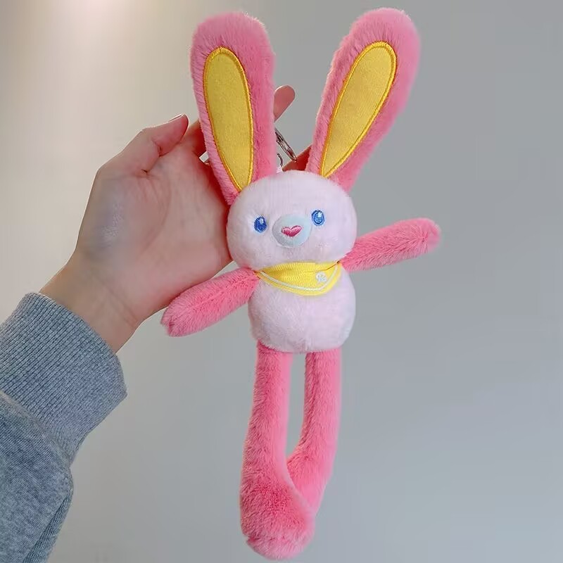 ネットの赤い耳のウサギはウサギの鍵を引いてぬいぐるみのかばんのペンダントを掛けて女の子にプレゼントします。|undefined