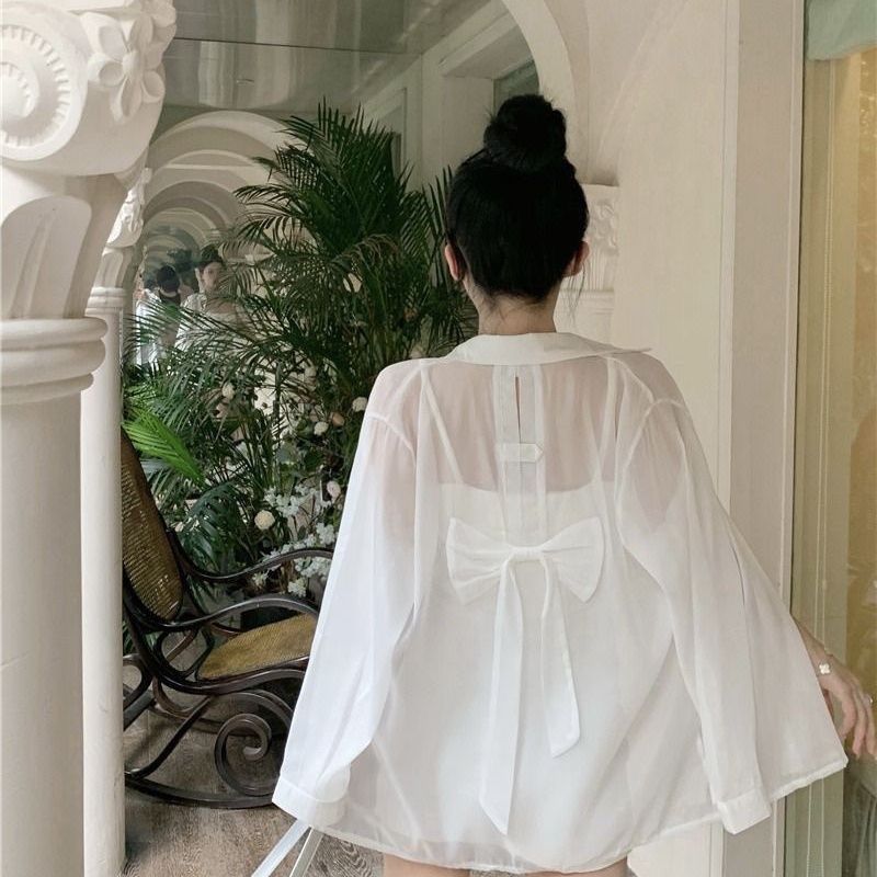 薄いタイプの微透長袖日焼け止めカーディガンの背中には、青いシャツ付きの女性夏のファッションカジュアルシャツのコートがあります。|undefined