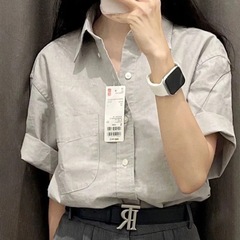 グレーの綿の半袖のシャツの女性の春の夏の薄いタイプのデザイン感の小さい大衆のゆったりしているシャツのフランスの高級感の上着