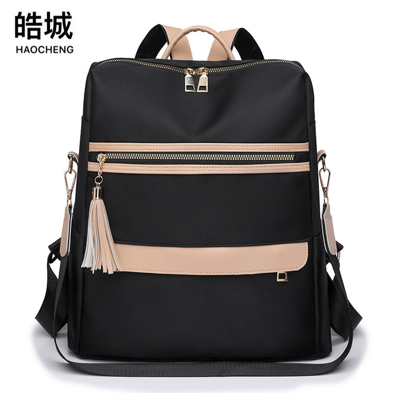 Comercio exterior al por mayor 2023 verano nuevas señoras mochila de nailon moda contraste color borla mochila de viaje de doble uso marea