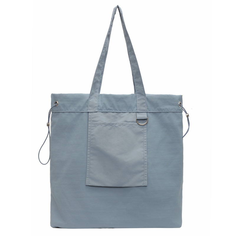 Bolsa de tela de nylon impermeable para mujeres 2025 nuevo tipo bolso de cubo de viaje ligero de gran capacidad bolso de hombro portátil para estudiantes universitarios