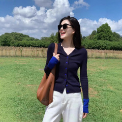 韓国系の衝突色vネックの肩の長袖のニットのカーディガンの女性の春と秋の修身の短いタイプの底のシャツの外で上着を掛けます。