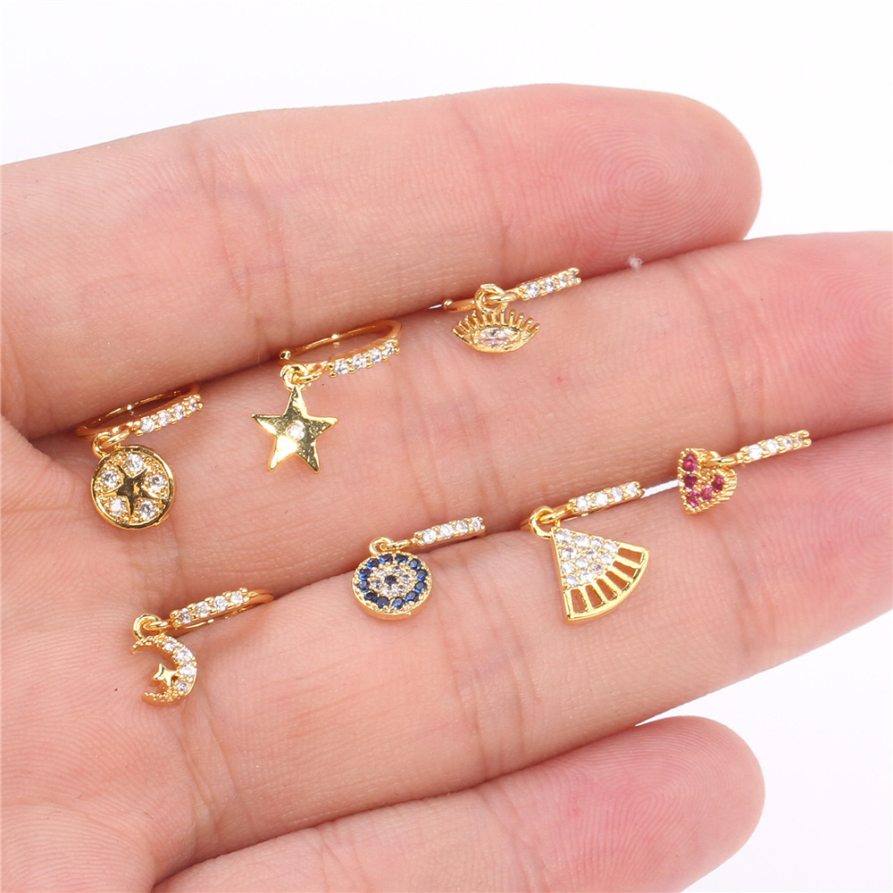 Anello transfrontaliero europeo e americano con mini cuore intarsiato di diamanti, ciondolo a forma di luna con occhio di diavolo blu e piercing al naso_voghion.com