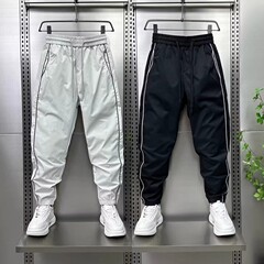夏の薄いタイプのサイドバーは足のカジュアルなズボンの男性の速乾のごろつきのかっこいい小さい足のズボンをつなぎ合わせて穴を開けて空気を通してエアコンのズボンを通します。