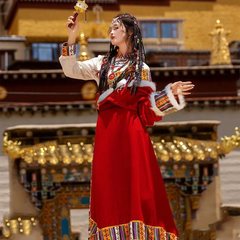 緑のチベット服のレトロな伝統的な女性ラサのガウンはチベット族のダンスに服を着て公演します。