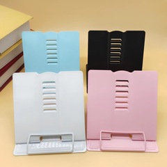 子供の読書棚の上の本棚のデスクトップの本を挟んで本棚を読んで本を読むスタンドは視力を保護して座っています。