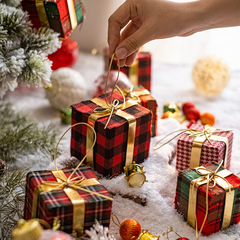クリスマスプレゼントの箱にクリスマスツリーの装飾品が飾られています。