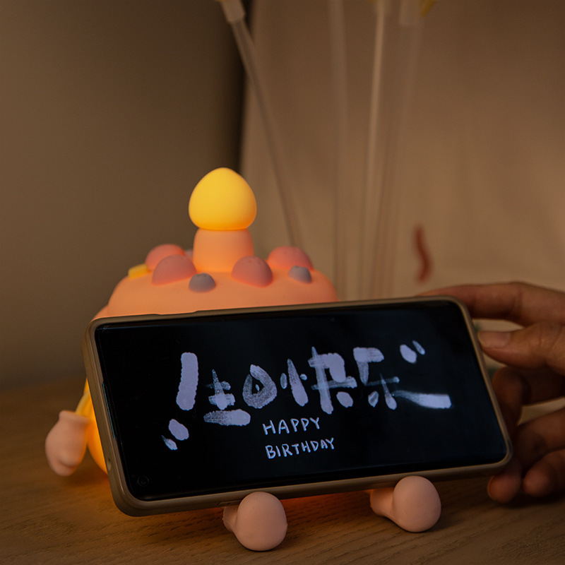 創意的な誕生日ケーキの小夜灯のベッドの上に飾られています。|undefined
