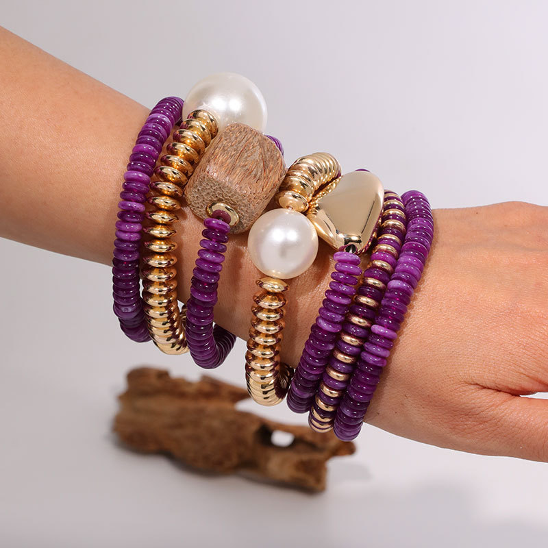 Exaggerated Pearl and Wood Block Embellishments with Gold Accents in Purple and Gold Color-Blocking Bohemian Fashion Stackable Bracelets from the Jewelry Factory Exaggerated Pearl and Wood Block Embellishments with Gold Accents in Purple and Gold Color-Blocking Bohemian Fashion Stackable Bracelets from the Jewelry Factory