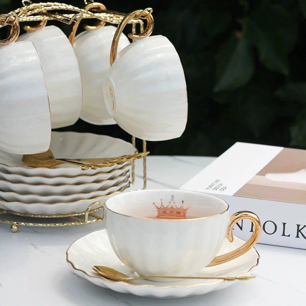 6 cups, 6 saucers, 6 gold spoons, 1 gold stand