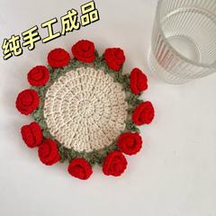 完成品の手作りのバラの花束のコースターの毛糸のかぎ針は杯を編みます。