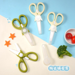 子供用陶磁器の副食はさみ赤ちゃんの陶磁器は食べ物を切ります。