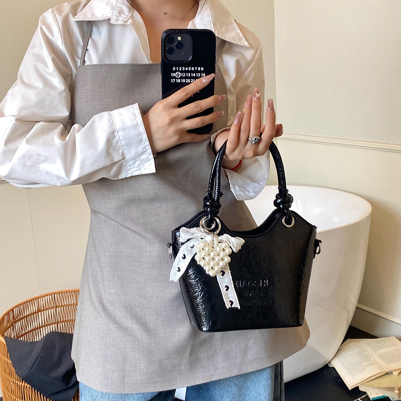 Bolso de mano de estilo occidental de ocio para mujer 2025 nuevo producto de moda de cercanías bolso de mensajero de un solo hombro de todo fósforo bolso de cubo de cuero de cera de aceite