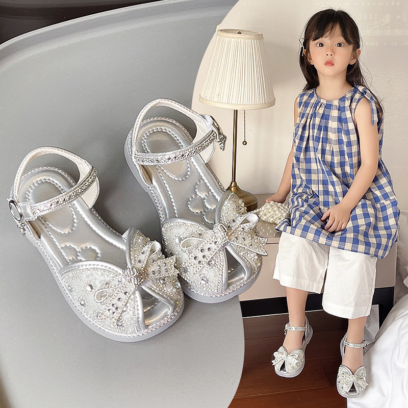 Sandalias Baotou para niñas 2025 verano nuevo estilo bowknot moda cristal princesa zapatos de playa para niños de suela suave marea