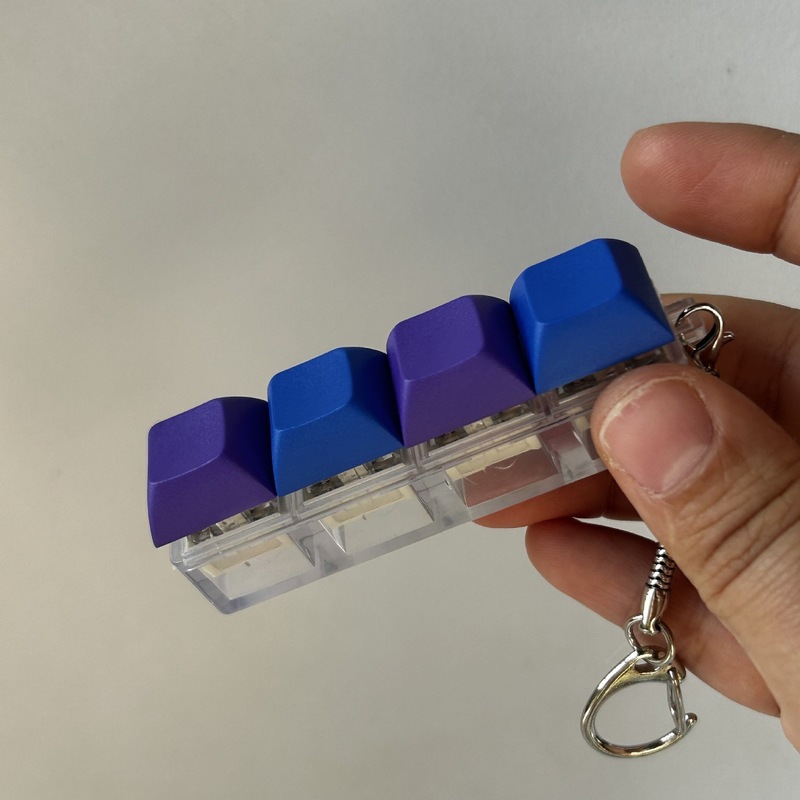 クロスボーダーカラー一字型四ボタンのキーホルダーの指先を押して解凍します。|undefined