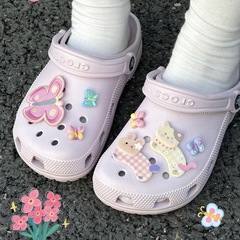カラフルな蝶の子猫の花園の穴の靴のボタンがかわいいです。