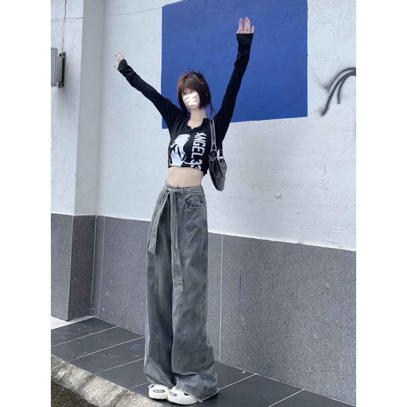 ズボンの女性の背の高い秋のレトロなジーパンを長くして、古い散歩をします。|undefined
